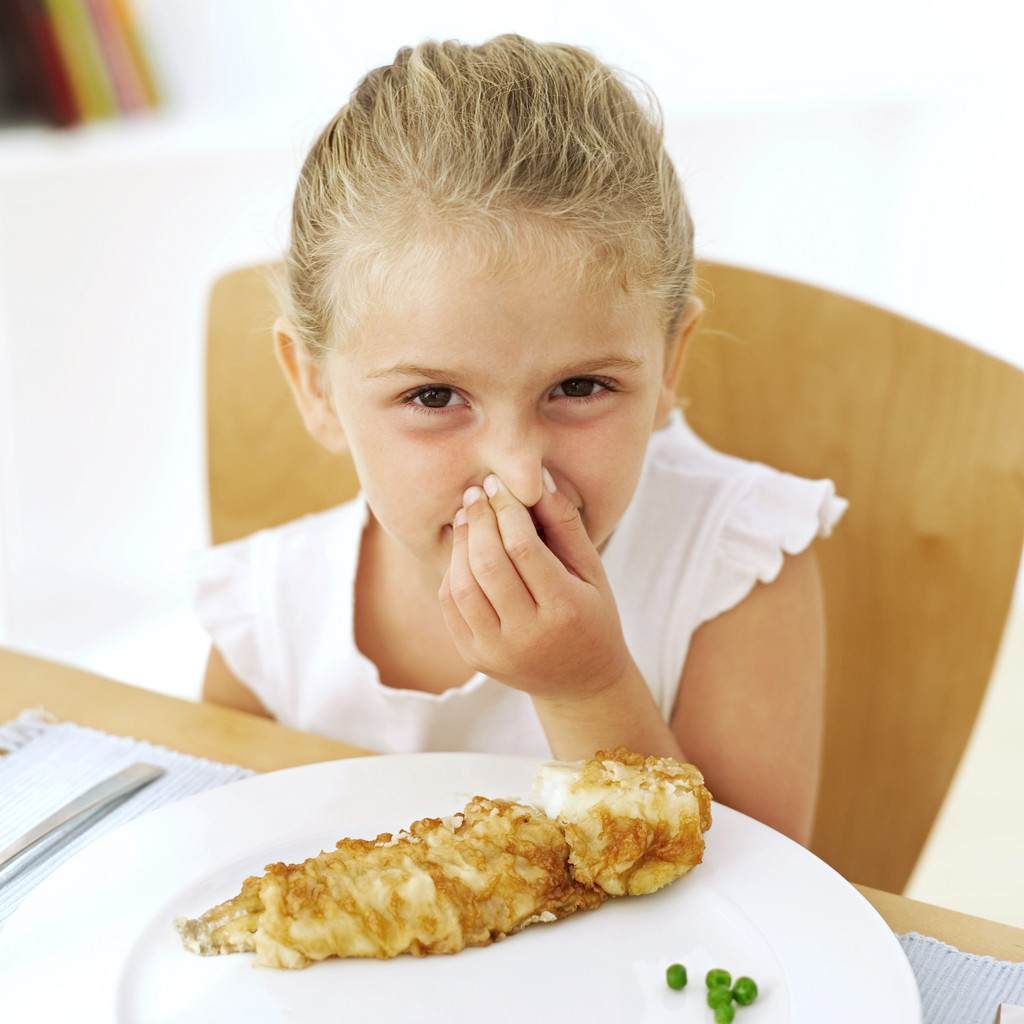 Young Girl Holding Her Nose at the Dinner Table.